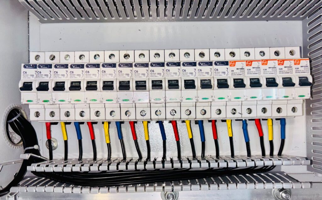 pexels-photo-28950842 Close-up of an organized circuit breaker panel featuring color-coded electrical wiring.